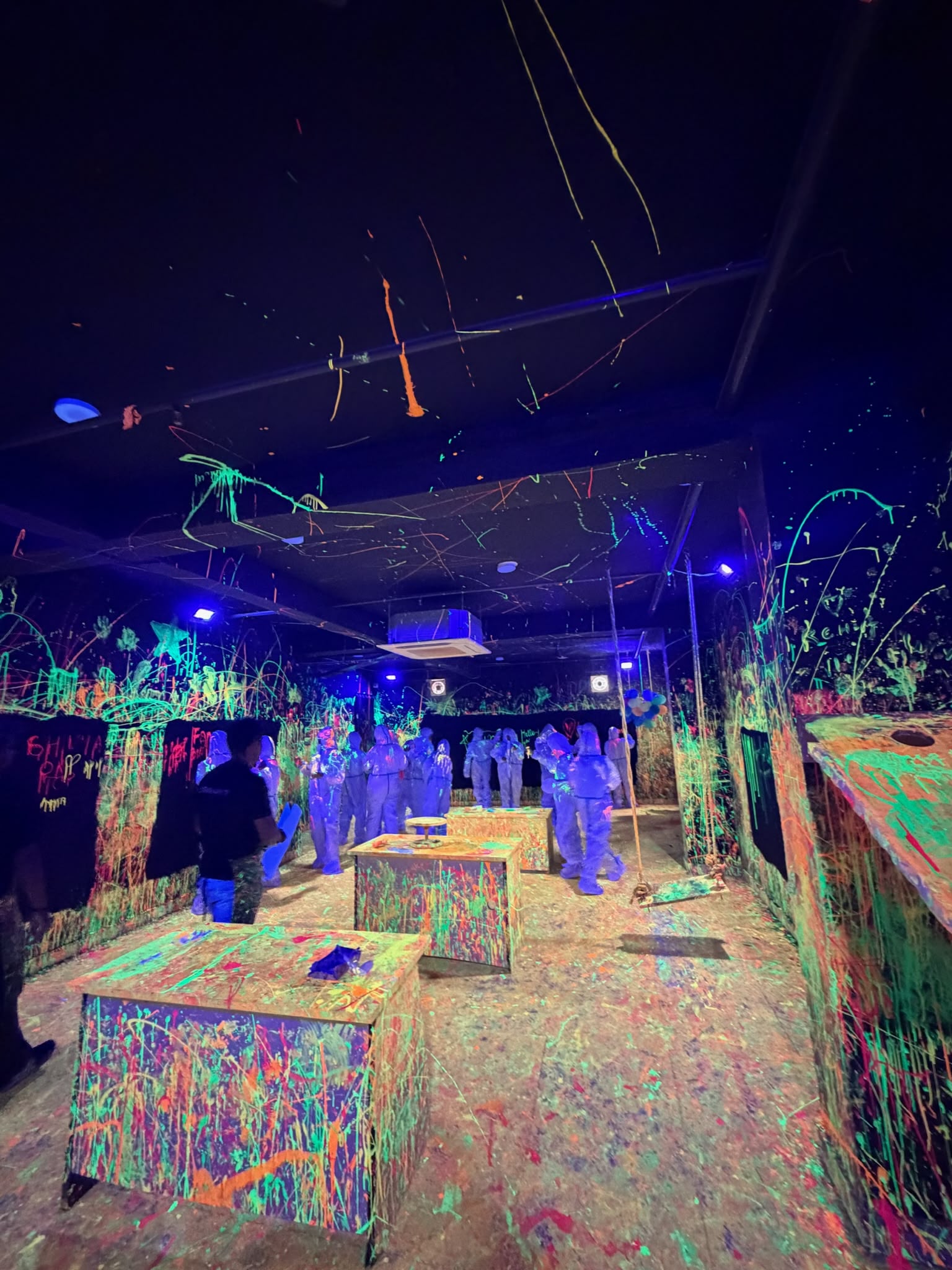 Glowing neon paint splatters on the wall at Splashit